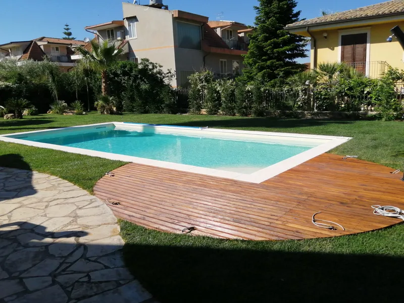 Piscina rettangolare con villa moderna sullo sfondo